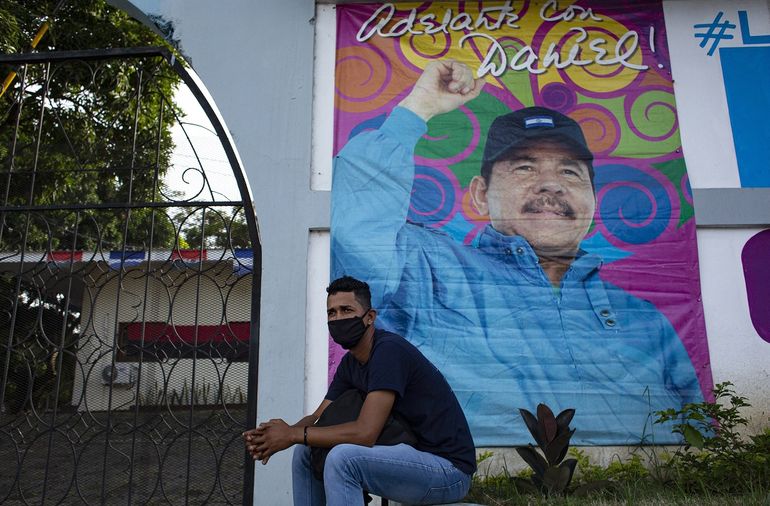 Un hombre se sienta frente a una pancarta que promueve la candidatura del presidente de Nicaragua, Daniel Ortega, en Managua el 24 de septiembre de 2021. Nicaragua inicia oficialmente la campaña para las elecciones presidenciales del 7 de noviembre el sábado, con los principales rivales del presidente Daniel Ortega arrestados y el camino libre para él. buscar un cuarto mandato consecutivo en el cargo.    