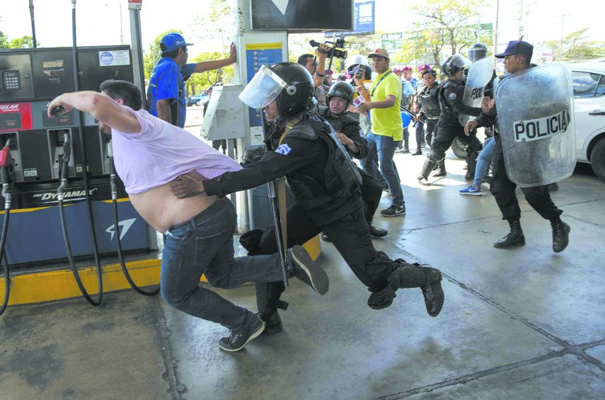 Policía Nacional de Nicaragua trata de detener al reportero gráfico Luis Sequeira, de la agencia AFP, durante una manifestación.