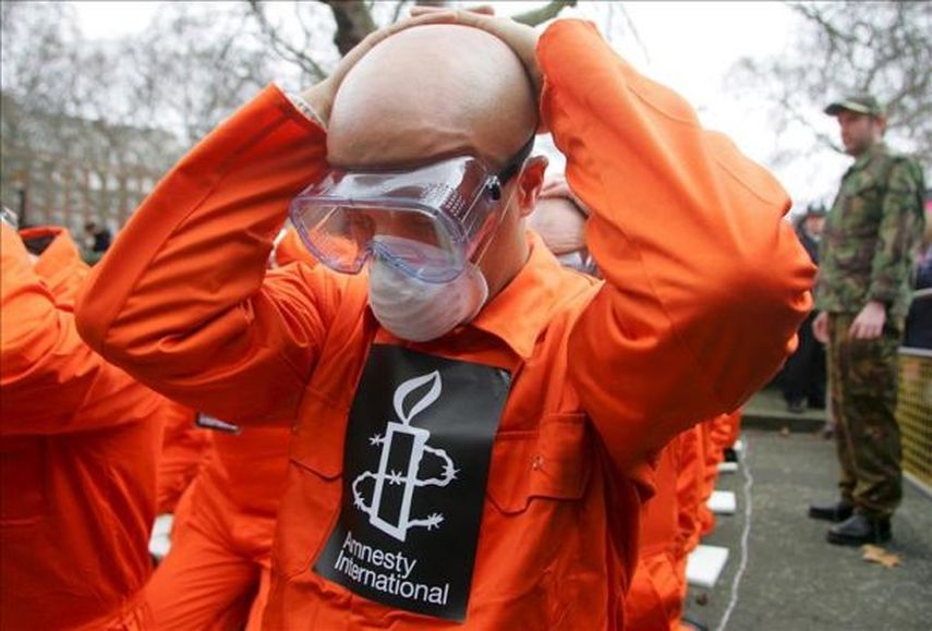 Activistas de la organización de derechos humanos Amnistía Internacional (AI) vestidos con monos naranja (como los presos de Guantánamo) (EFE/Archivo)