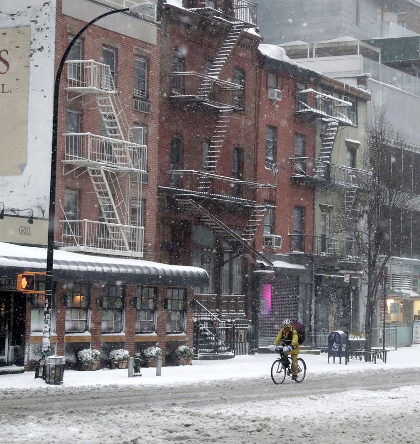 Un hombre conduce su bicicleta por una calle nevada de Nueva&nbsp;York.
