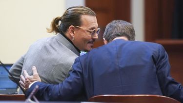El actor Johnny Depp habla con un miembro de su equipo legal en el Tribunal de Circuito del Condado de Fairfax, el jueves 19 de mayo de 2022 en Fairfax, Virginia.&nbsp;