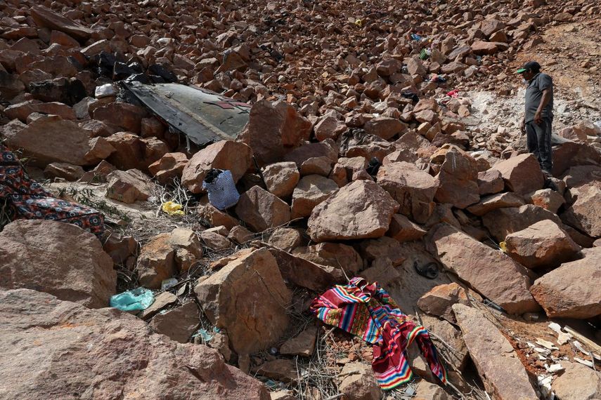 Un hombre observa los restos de un autobús y algunas pertenencias de los pasajeros tras caer a un barranco de unos 200 metros de profundidad en Arequipa, Perú, el 12 de noviembre de 2025. Al menos 37 personas murieron y otras 24 resultaron heridas el miércoles en el sur de Perú cuando un autobús de dos pisos cayó a un barranco tras chocar con una camioneta, informaron las autoridades.