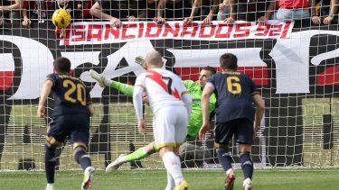 El delantero español del Rayo Vallecano #22 Raúl de Tomás (no visto) anota el primer gol de su equipo desde el punto de penalti a pesar del portero ucraniano del Real Madrid #13 Andriy Lunin durante el partido de fútbol de la liga española Rayo Vallecano de Madrid y Real Madrid CF en Vallecas Estadio de Madrid el 18 de febrero de 2024. &nbsp;