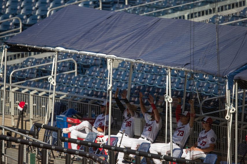 Peloteros de los Nacionales de Washington observan el juego desde el anexo del dugout en las gradas, al enfrentar a los Filis de Filadelfia, el s&aacute;bado 18 de julio de 2020&nbsp;