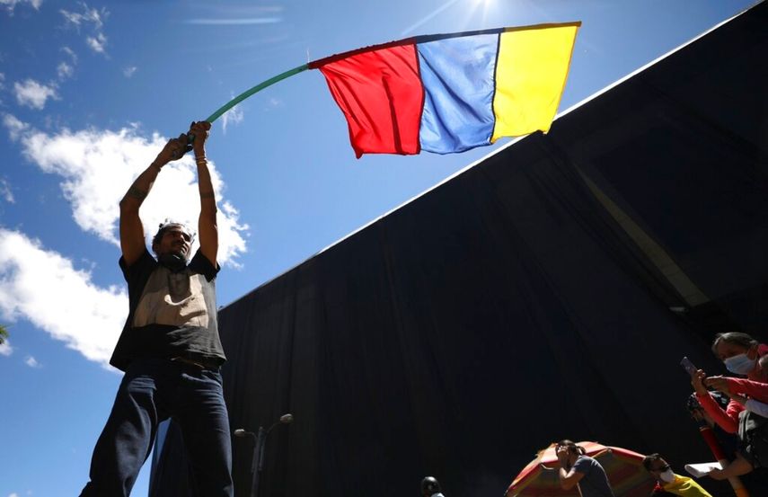 Un hombre ondea una bandera de Colombia el miércoles 2 de junio de 2021 durante una manifestación antigubernamental, la cual fue desatada por una propuesta de incremento fiscal a los servicios públicos, el combustible, los salarios y las pensiones, en Bogotá, Colombia.