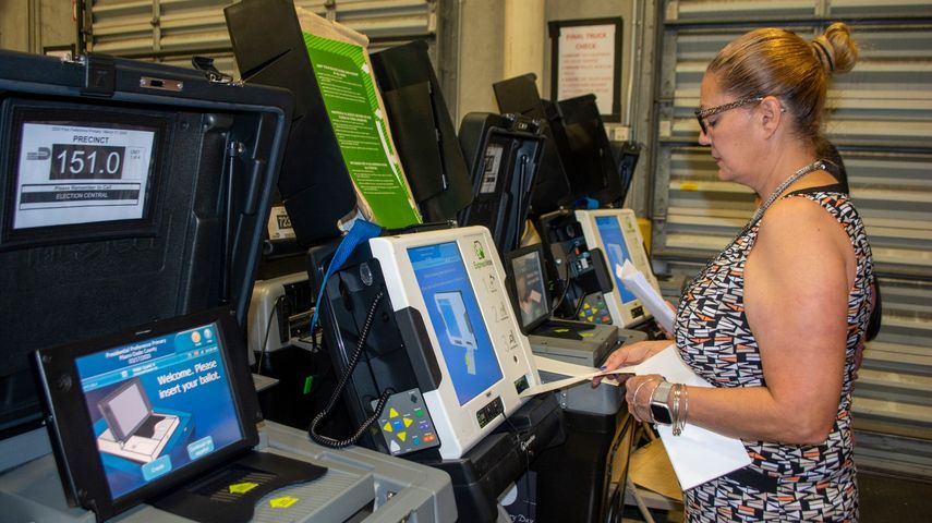 Una empleada de la autoridad de Elecciones de Miami-Dade prueba una de las m&aacute;quinas contadoras de votos.