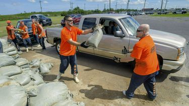 Presos de la comisaría de la parroquia St. Bernard entregan bolsas de arena a los residentes de Chalmette, Luisiana, 11 de julio de 2019, a la espera de la tormenta tropical Barry.&nbsp;