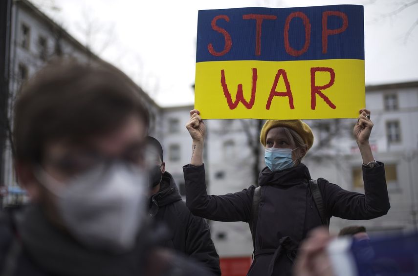 Una mujer con un cartel con los colores de la bandera ucraniana que dice Alto a la guerra asiste a una manifestación contra las tensiones entre Rusia y Ucrania, cerca de la embajada rusa en Berlín, Alemania, el martes 22 de febrero de 2022.&nbsp;