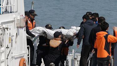 Socorristas cargan el cadáver de un pasajero que iba a bordo del ferry hundido en las costas de Corea del Sur, en el puerto de Jindo, el 20 de abril de 2014. El Sewol se hundió el miércoles con 476 personas a bordo, la mayoría jóvenes estudiantes.