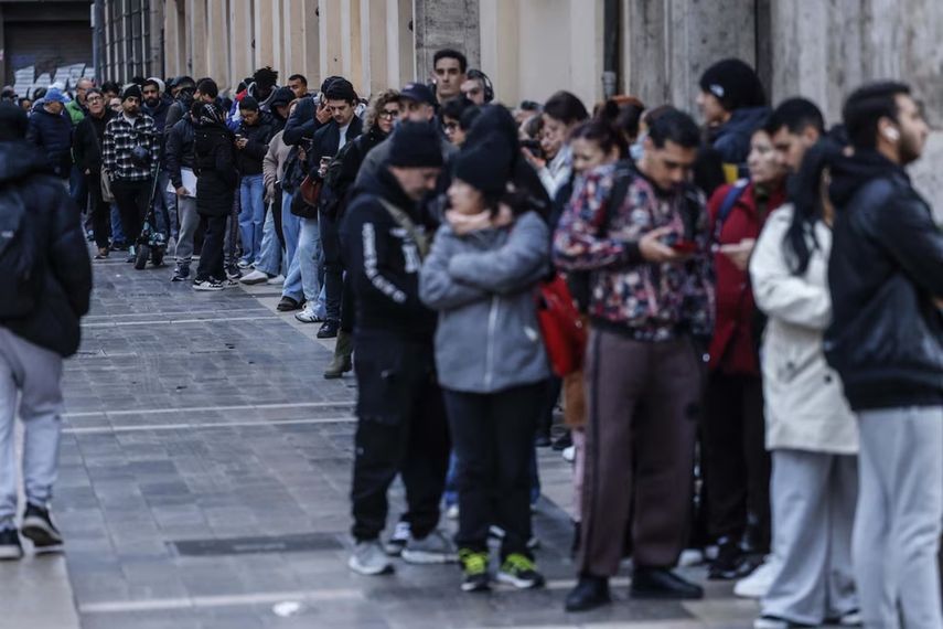 Inmigrantes en España hacen cola para iniciar tramites hacia la regularización extraordinaria.