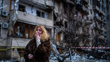 Vecina de Kyiv, Ucrania, llora frente al edificio destruido, donde vivía.