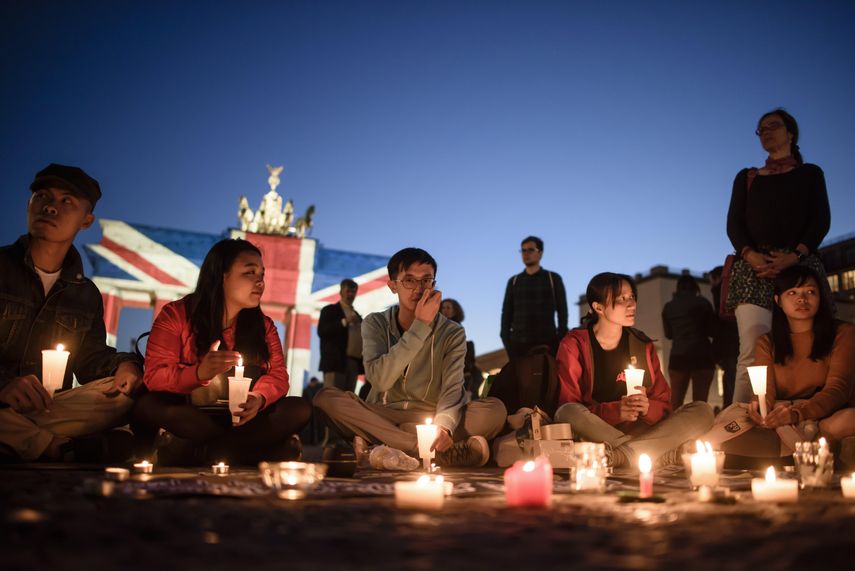 Protestors sit around a banner to remember the massacre on the Chinese Tiananmen Square in 1989 in front of the Brandenburg Gate, illuminated in the colors of the British Union Jack to show solidarity with the victims after the 03 June terror attack in central London, in Berlin, Germany, 04 June 2017. At least seven members of the public were killed and dozens injured after three attackers on late 03 June plowed a van into pedestrians and later randomly stabbed people on London Bridge and nearby Borough Market. The three attackers wearing fake suicide vests were shot dead by police who are treating the attack as a terrorist incident. (Londres, Atentado, Terrorista, Protestas, Alemania) EFE/EPA/CLEMENS BILAN