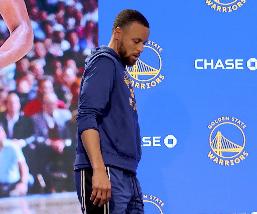 Stephen Curry, de los Warriors de Golden State, camina rumbo a una conferencia de prensa para atender a los medios de comunicación sobre su lesión, previo al partido de baloncesto contra los Spurs de San Antonio, en San Francisco, el domingo 20 de marzo de 2022.