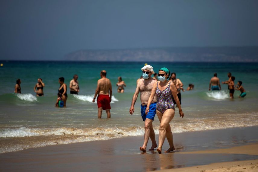 &nbsp; Una pareja con mascarillas camina por la playa en C&aacute;diz, sur de Espa&ntilde;a, 21 de julio de 2020.&nbsp; &nbsp;