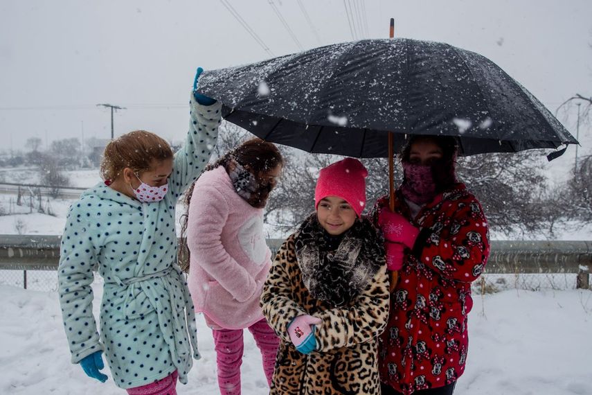 Unos niños se protegen de la nieve en la localidad Canadá Real a las afueras de Madrid, España, el 8 de enero de 2021.&nbsp;