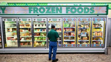 Un cliente observa productos refrigerados en un supermercado.