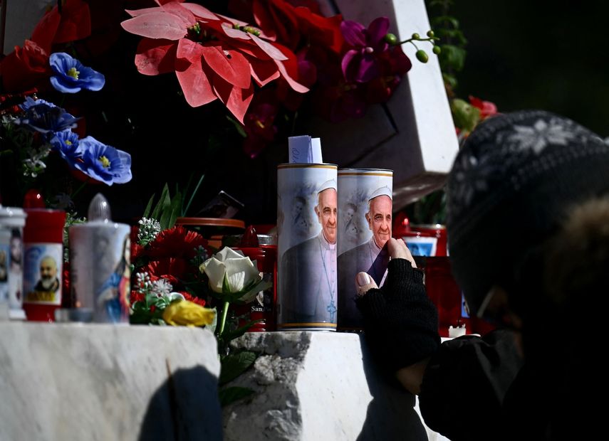 Una mujer reza frente a las velas del Papa Francisco en el exterior del hospital Gemelli, donde el Papa Francisco está internado para realizarle pruebas y recibir tratamiento por bronquitis en Roma, el 21 de febrero de 2025.&nbsp;