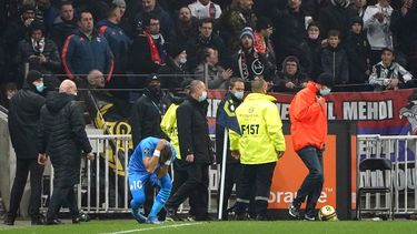 Dimitri Payet del Marsella reacciona tras ser agredido por un proyectil lanzado desde la grada durante el partido contra Lyon por la Ligue 1 en Francia