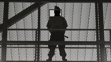 Oficiales de seguridad de la prisión del gobierno de El Salvador montan guardia dentro de la prisión recién inaugurada.