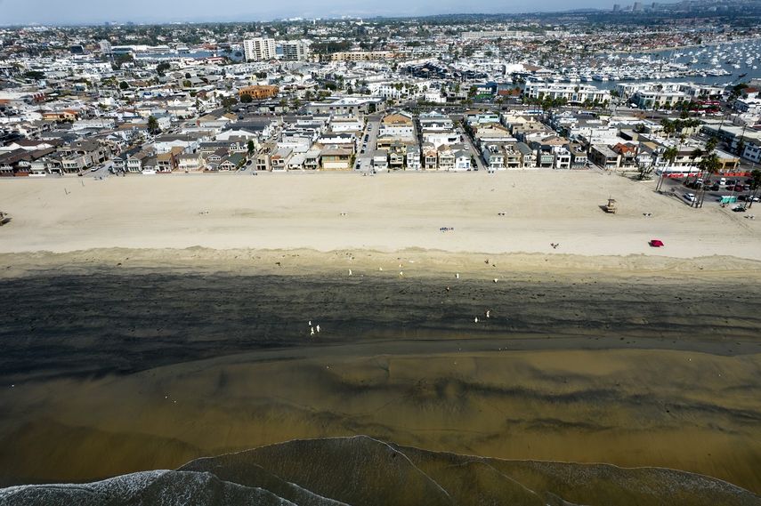 En esta imagen aérea tomada con un dron, trabajadores con trajes de protección limpian la playa contaminada por un derrame de petróleo en Newport Beach, California, el miércoles 6 de octubre de 2021.&nbsp;