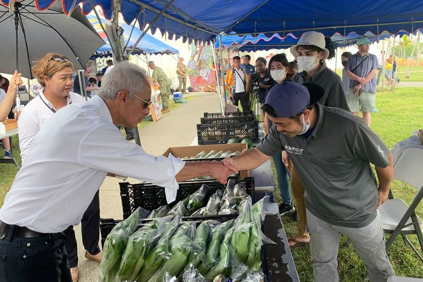 El embajador de Estados Unidos en Japón, Rahm Emanuel, saluda a un vendedor local en el mercado de agricultores de Camp Hansen, una base del Cuerpo de Marines de EEUU, en la isla de Okinawa, en el sur de Japón, el domingo 30 de octubre de 2022. Embajada de EEUU vía AP)
