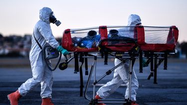 Miembros de la Brigada Militar de Bomberos de Minas Gerais (CBMMG) que usan equipo de protección, demuestran el uso de una camilla de aislamiento o camilla de burbujas, para transportar pacientes infectados con coronavirus (COVID-19), en el aeropuerto de Pampulha, en Belo Horizonte, estado de Minas Gerais, Brasil, el 22 de julio de 2020. El equipo, que puede utilizarse para transportar pacientes en aviones y ambulancias, filtra el aire que exhala el paciente además de aislarlo.