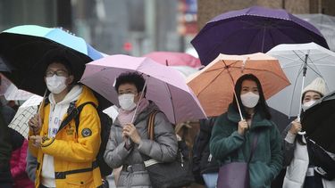 Un grupo de gentes, protegidos con m&aacute;scarillas quir&uacute;rgicas, en el distrito comercial de Ginza, en Tokio.