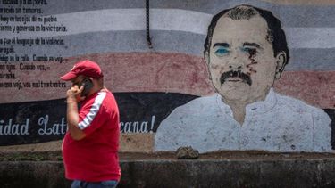 Un hombre camina junto a un estropeado mural del dictador de Nicaragua, Daniel Ortega, en Managua el 14 de abril de 2020.