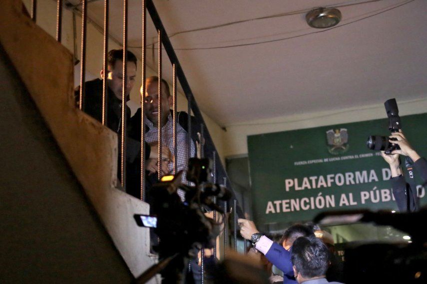 Luis Fernando Camacho (derecha), una figura clave de la oposición y gobernador de la potencia económica de la región de Santa Cruz, es escoltado por una escalera al llegar a la sede de las Fuerzas Especiales de Lucha contra el Crimen (FELCC) en La Paz, Bolivia, tras ser detenido por el régimen del MAS de Evo Morales.
