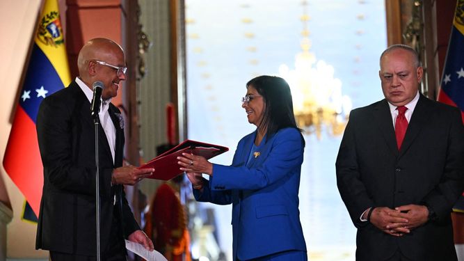 La gobernante interina de Venezuela, Delcy Rodríguez, recibe la ley de amnistía de manos de su hermano y presidente de la Asamblea Nacional, Jorge Rodríguez, mientras el ministro del Interior, Justicia y Paz, Diosdado Cabello, expresa malestar en su rostro durante la entrega de la ley, en el Palacio de Miraflores en Caracas el 19 de febrero de 2026.