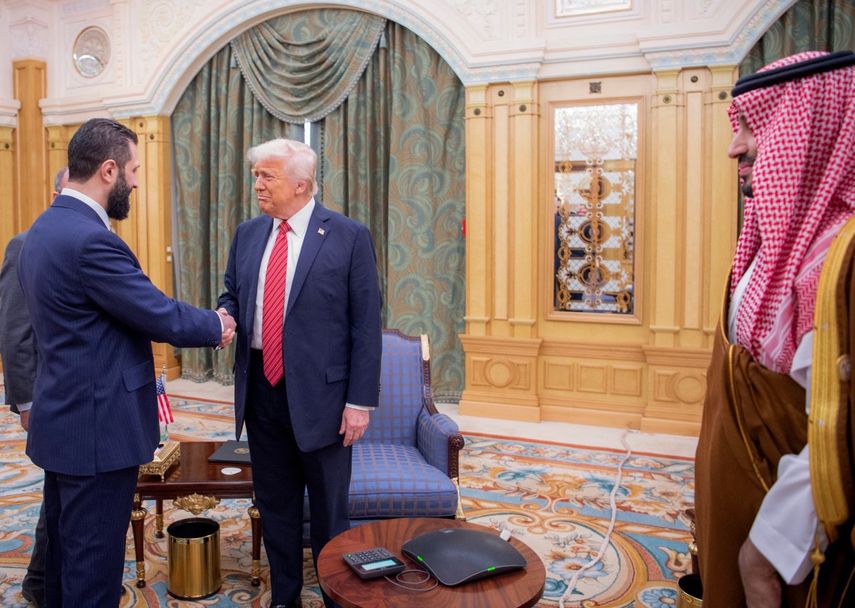El príncipe heredero saudita Mohammed bin Salman (der.) observa mientras el presidente Donald Trump estrecha la mano del presidente interino de Siria, Ahmed al-Sharaa, en Riad.