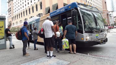 Miamenses abordan un autob&uacute;s en Miami.