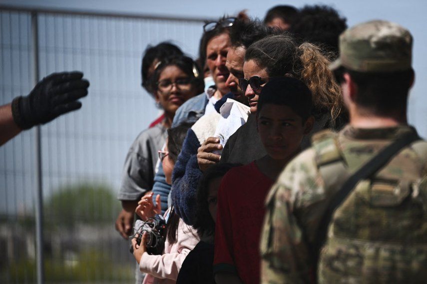 Migrantes hacen cola para en la frontera para solicitar asilo en Estados Unidos.