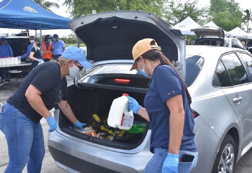 Voluntarios colocaban los alimentos en la parte trasera de los veh&iacute;culos.