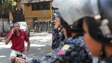 Efectivos policiales bloquean la vía por la cual pasaría una marcha de trabajadores públicos en Caracas.