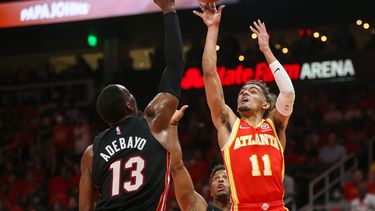 El base de los Hawks de Atlanta Trae Young lanza el balón entre el pívot Bam Adebayo y el base Kyle Lowry del Heat de Miami en el encuentro de la primera ronda de la postemporada del viernes 22 de abril del 2022 en Atlanta.&nbsp;