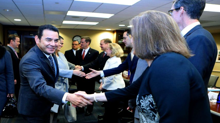 El presidente Jimmy Morales saluda a varias personas durante una reunión en Washington
