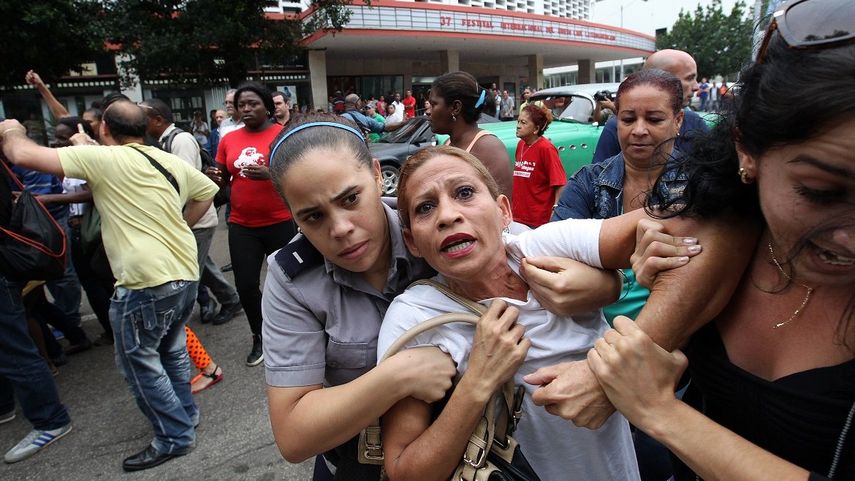 Una de las integrantes de las Dama de Blanco es reprimida por agentes de la policía política en La Habana, Cuba.