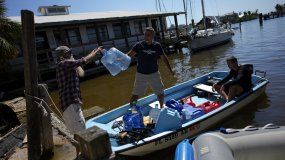 Los miembros de la comunidad de navegantes se ayudan mutuamente transportando suministros que incluyen agua y combustible, tras el paso del huracán Ian, en la isla de San Carlos en Fort Myers Beach, Florida, el viernes 7 de octubre de 2022. 