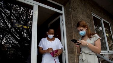 Una trabajadora de salud cubana deja una oficina de Western Union después de cobrar dinero mientras otra clienta espera su turno el último día de trabajo de la oficina en La Habana, Cuba. 