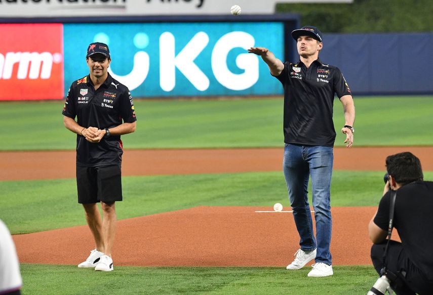 Los pilotos de Red Bull, Sergio Pérez (Izquierda) y Max Verstappen (Derecha) realizan el primer lanzamiento en el juego de los Marlins de Miami contra Cascabeles de Arizona la noche del miércoles 4 de mayo de 2022