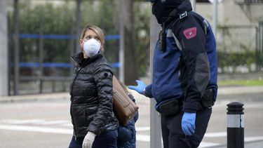 Un polic&iacute;a habla con una mujer y su ni&ntilde;a en una desolada avenida en Madrid.