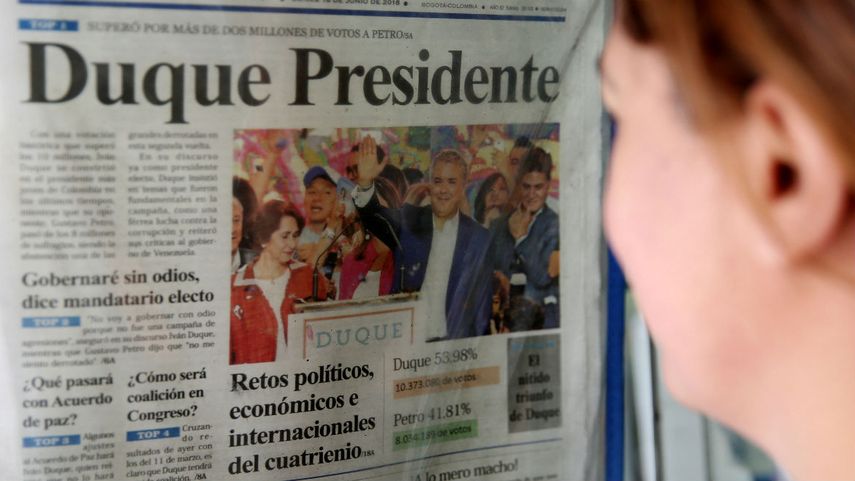 Una mujer, en Bogotá, lee la página de un periódico que reseña la noticia del triunfo de Iván Duque en las elecciones de Colombia.