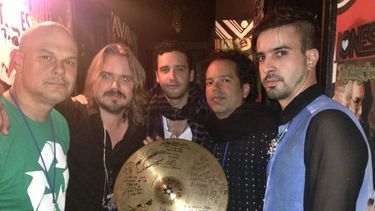 Miembros de la agrupación junto al platillo que subastan. (EBAY)