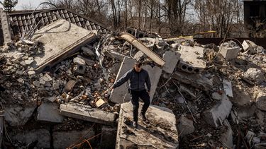 Un policía camina entre los escombros de una casa destruida en la aldea de Bohdanivka, al noreste de Kiev, el 14 de abril de 2022, en medio de la invasión de Rusia a Ucrania.