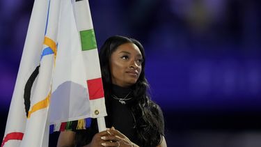 La gimnasta estadounidense Simone Biles sostiene la bandera olímpica durante la ceremonia de clausura de los Juegos Olímpicos de verano de 2024 en el Stade de France, el domingo 11 de agosto, en Saint-Denis, Francia.