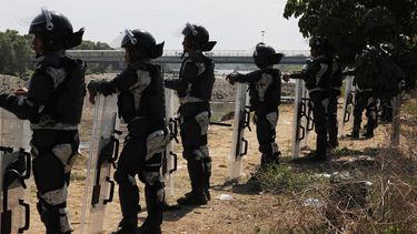Efectivos de la Guardia Nacional permanecen en el lado mexicano de la orilla del r&iacute;o Suchiate cerca de Ciudad Hidalgo, M&eacute;xico, en la frontera con Guatemala, el martes 21 de enero de 2020, para impedir el paso a cientos de migrantes centroamericanos.