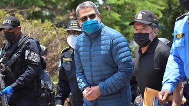 El expresidente de Honduras Juan Orlando Hernández, que esposado es trasladado al avión que lo lleva en condición de extraditado a EEUU.