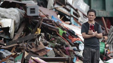 Un superviviente del tifón Haiyan permanece de pie en silencio entre las casas dañadas en la ciudad de Tacloban, Filipinas, el lunes 11 de noviembre de 2013. (Foto AP/Aaron Favila)