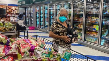 Una mujer observa con detenimiento los precios de alimentos en un supermercado.